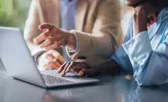 Team Collaborating over Laptop in Office
