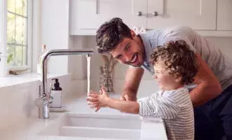 Father Helping Son To Wash Hands