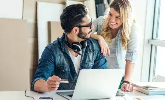 Happy couple shopping online on a computer