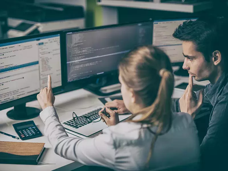 Capita’s Software-defined WAN services 2 people looking at computer code