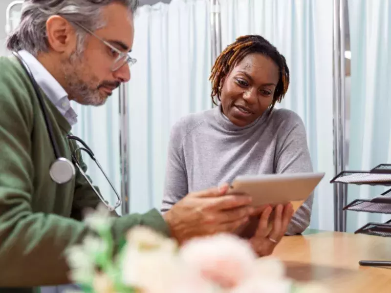 Better experiences in healthcare Doctor & Women looking at tablet